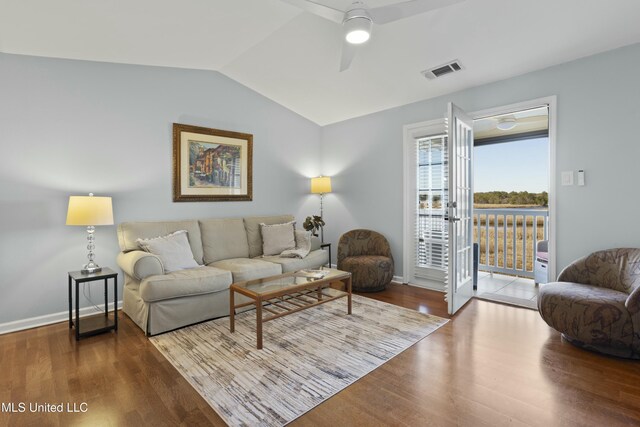 living area with ceiling fan, visible vents, vaulted ceiling, and wood finished floors