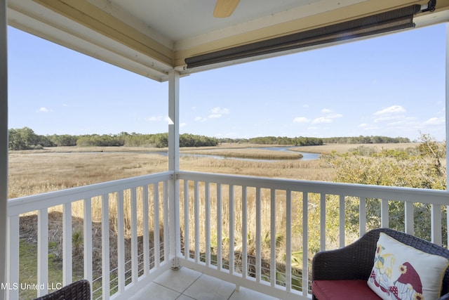 balcony with a water view and ceiling fan