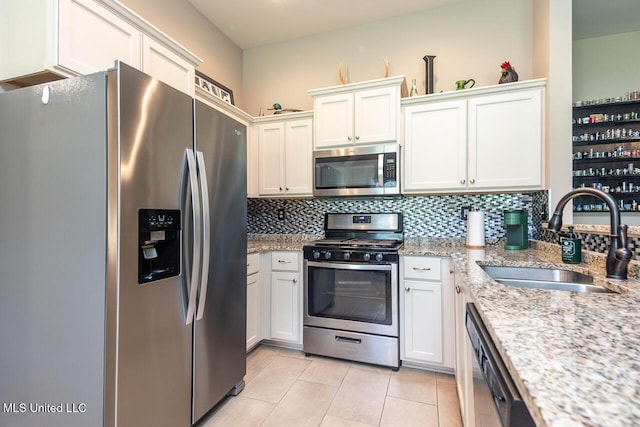 3289 Marion Ln, Southaven, MS 38672 - kitchen with stainless steel appliances, decorative backsplash, light tile patterned flooring, white cabinets, and light stone counters