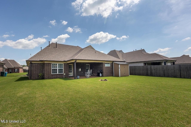 3289 Marion Ln, Southaven, MS 38672 - rear view of house featuring a storage shed, a fenced backyard, brick siding, a patio area, and roof with shingles