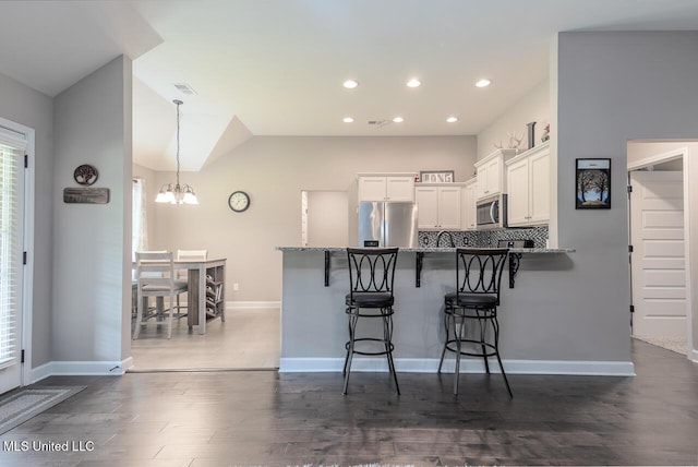 3289 Marion Ln, Southaven, MS 38672 - kitchen featuring stainless steel appliances, a peninsula, a kitchen breakfast bar, white cabinets, and a chandelier