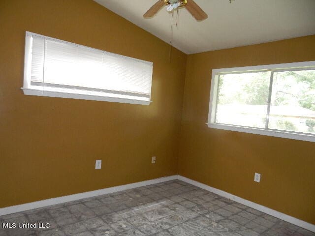 unfurnished room with ceiling fan and vaulted ceiling