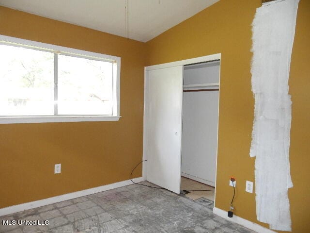 unfurnished bedroom with a closet and vaulted ceiling