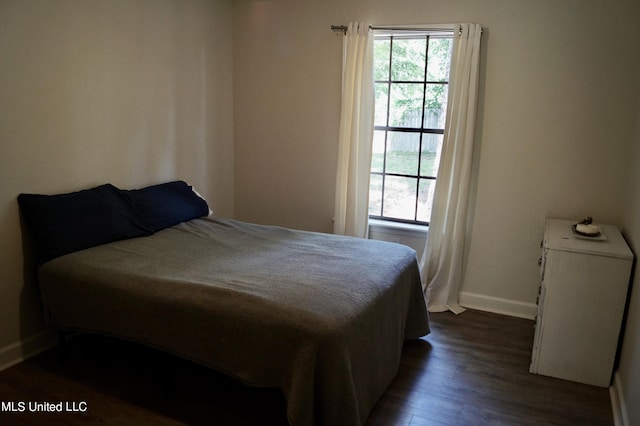 bedroom with dark hardwood / wood-style flooring