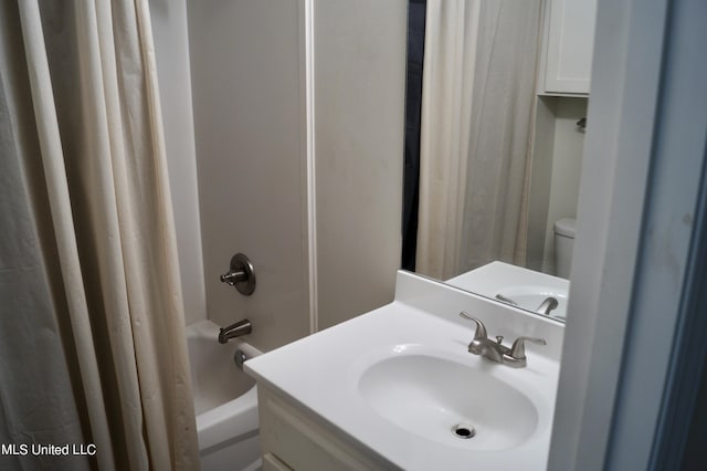 full bathroom with vanity, shower / bath combo, and toilet