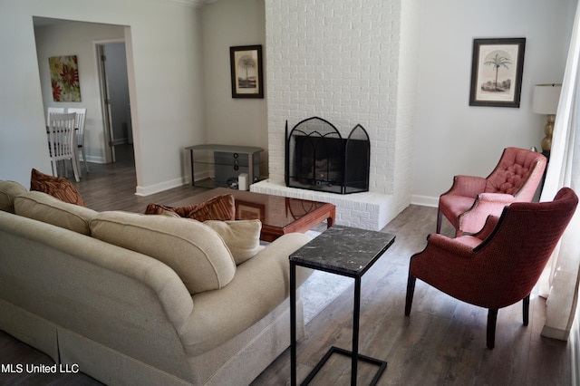 living room with hardwood / wood-style floors and a brick fireplace