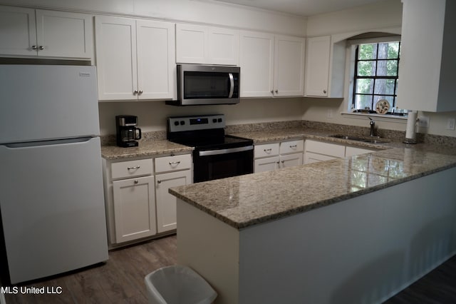 kitchen featuring kitchen peninsula, white cabinetry, stainless steel appliances, and dark hardwood / wood-style floors