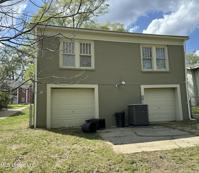 1054 Madison St, Jackson, MS 39202 - exterior space featuring cooling unit, brick siding, a garage, and a yard