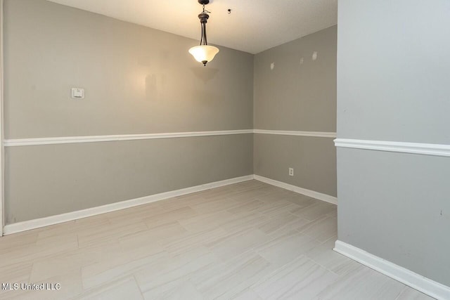spare room with baseboards