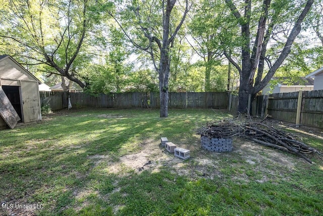 view of yard with a fenced backyard, an outdoor structure, and a storage shed