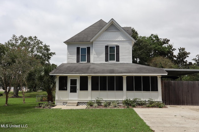 view of front facade featuring a front yard and a sunroom