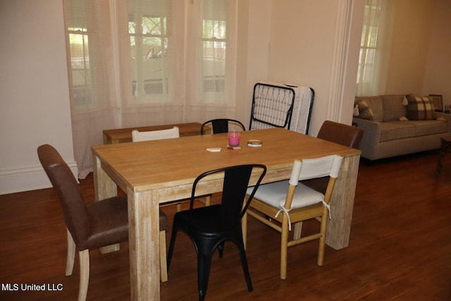 dining space with dark hardwood / wood-style flooring and plenty of natural light