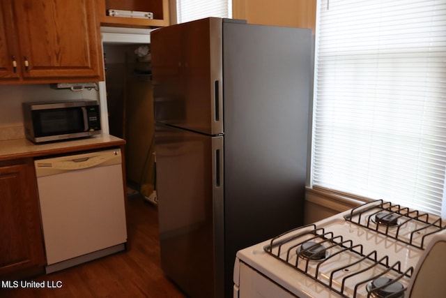 kitchen with appliances with stainless steel finishes and dark wood-type flooring