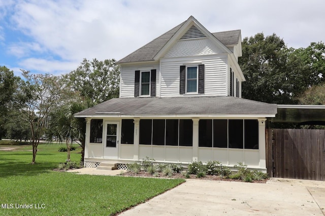 1009 Resca De La Palma St, Pascagoula, MS 39567 - view of front of house featuring a shingled roof, a sunroom, and a front lawn