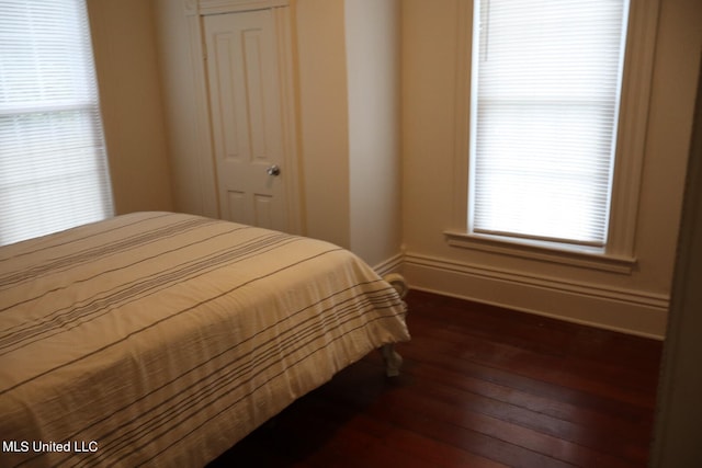 bedroom with dark hardwood / wood-style floors