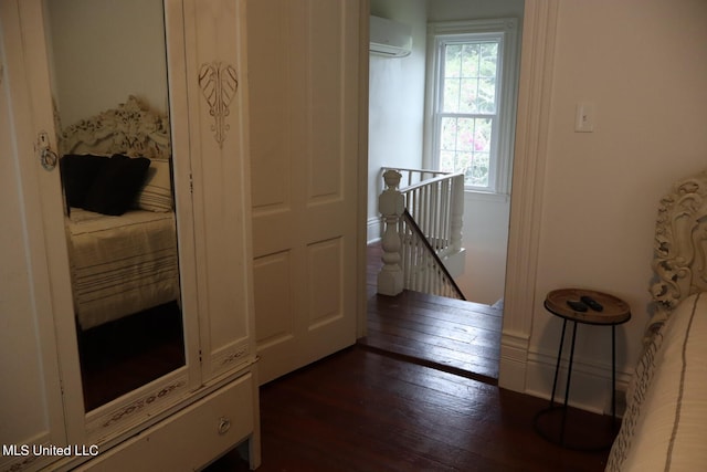 hall with a wall mounted AC and dark wood-type flooring