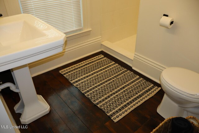 bathroom with toilet, hardwood / wood-style flooring, and walk in shower