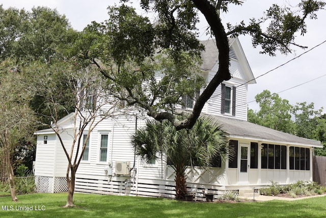 exterior space with ac unit, a yard, and a sunroom