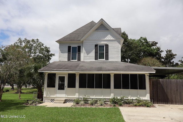 view of front of home featuring a sunroom and a front lawn