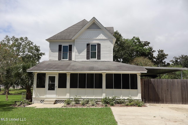 view of front facade with a front yard and a sunroom