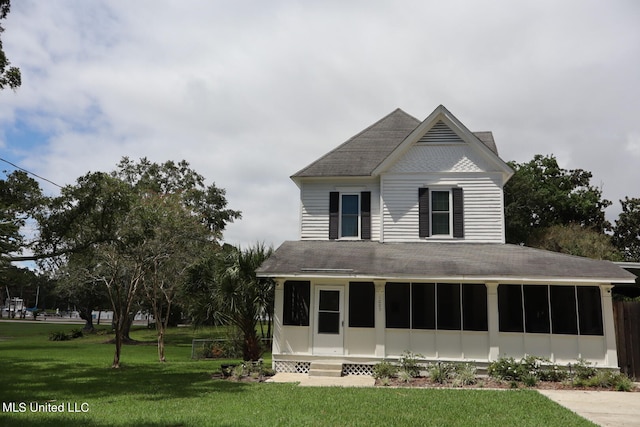 back of house featuring a yard and a sunroom