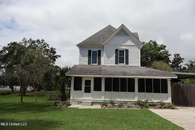 farmhouse-style home featuring a front yard and a sunroom