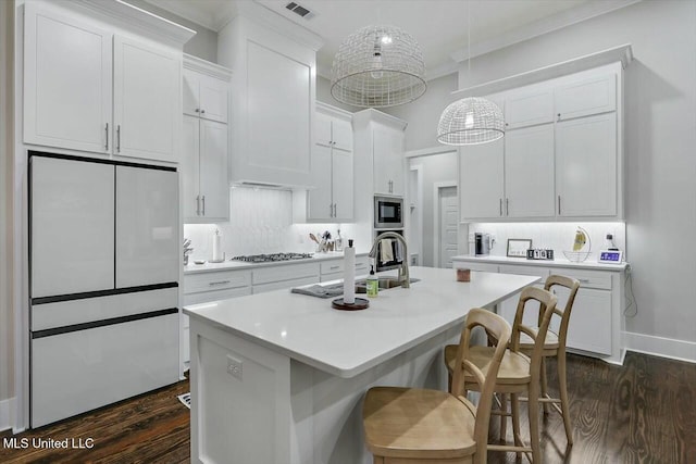 kitchen with a kitchen island with sink, white cabinetry, stainless steel appliances, and dark hardwood / wood-style floors