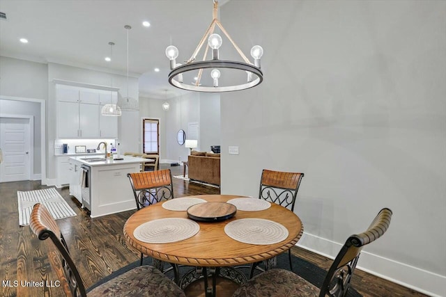 dining space with a chandelier, dark hardwood / wood-style floors, and sink