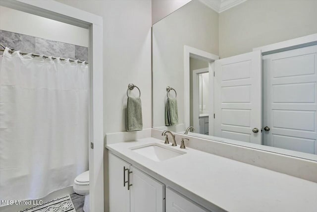 bathroom with vanity, toilet, and crown molding