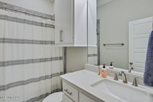 bathroom with vanity, toilet, and crown molding