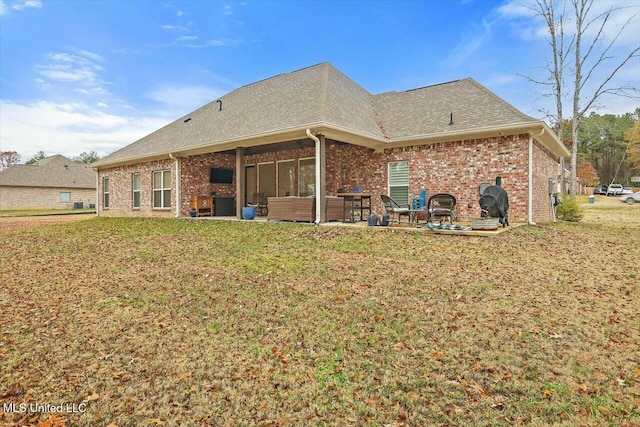 back of property with a lawn, an outdoor living space, and a patio area