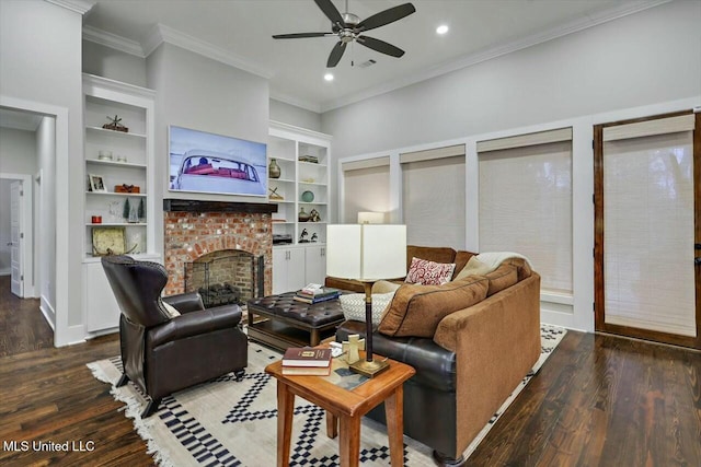 living room featuring ceiling fan, dark wood-type flooring, a brick fireplace, built in features, and ornamental molding