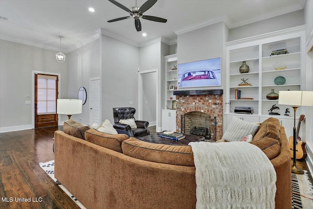 living room featuring built in shelves, ceiling fan, dark hardwood / wood-style flooring, a fireplace, and ornamental molding