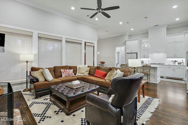 living room featuring dark hardwood / wood-style floors, ceiling fan, and ornamental molding