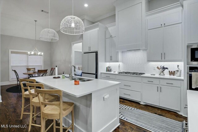 kitchen with a kitchen island with sink, white cabinetry, sink, and appliances with stainless steel finishes