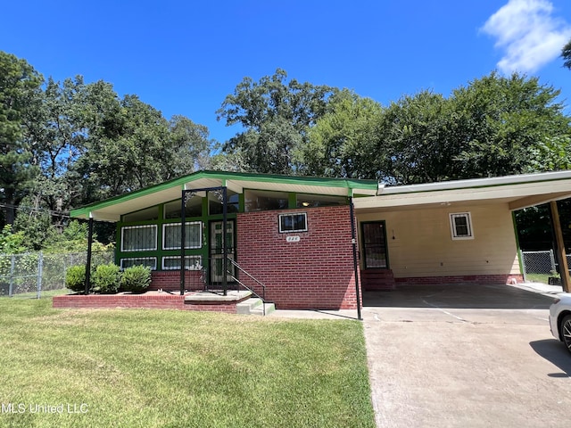 rear view of house with a yard and a carport