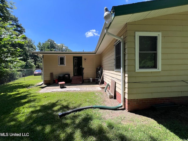 rear view of house featuring a yard and a patio