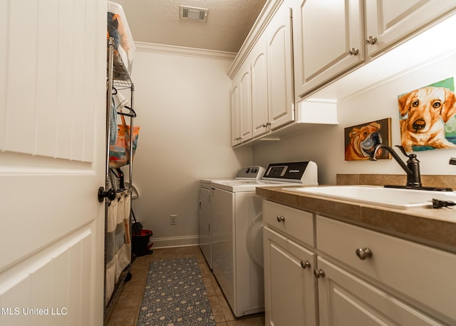 124 Westerly Pl, Madison, MS 39110 - laundry room featuring cabinet space, washing machine and clothes dryer, dark tile patterned floors, ornamental molding, and a textured ceiling