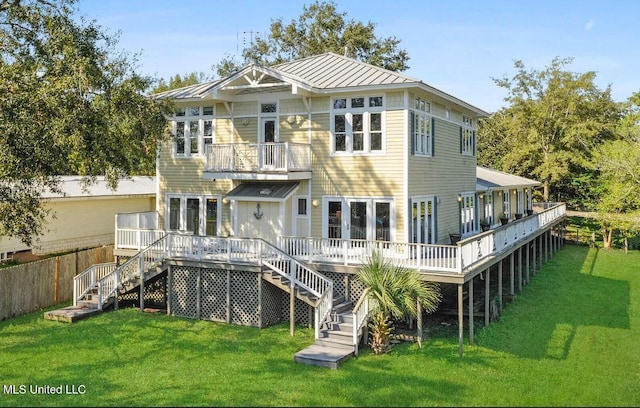 back of property featuring a deck, metal roof, stairway, a lawn, and a standing seam roof