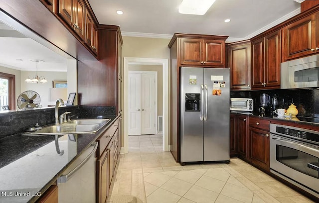 kitchen featuring stainless steel appliances, a sink, ornamental molding, dark stone counters, and tasteful backsplash