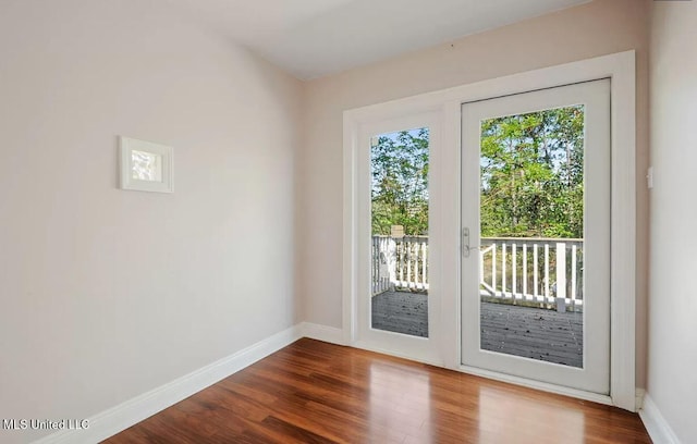 doorway featuring dark wood-style floors and baseboards