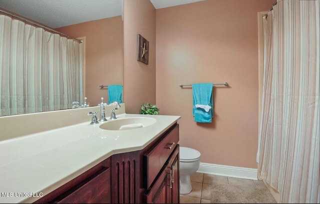 full bath with toilet, vanity, a textured ceiling, tile patterned flooring, and baseboards