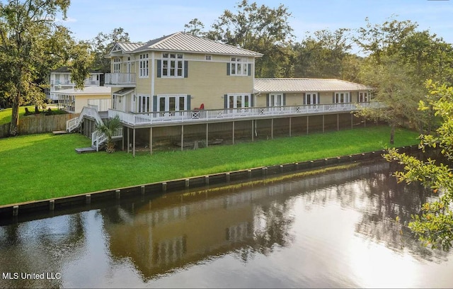 back of property featuring driveway, a lawn, a balcony, metal roof, and a standing seam roof