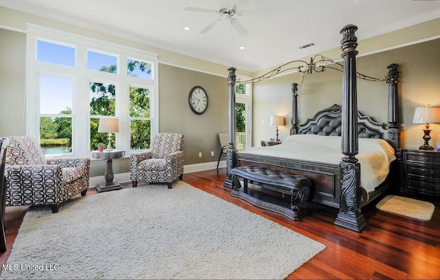 bedroom with a ceiling fan, visible vents, baseboards, and wood finished floors