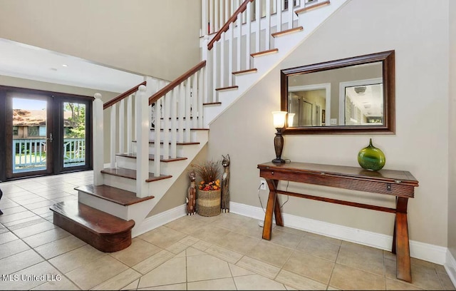 stairs featuring baseboards, french doors, and tile patterned floors