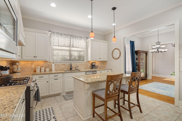 kitchen with white cabinets, sink, light wood-type flooring, appliances with stainless steel finishes, and a kitchen island