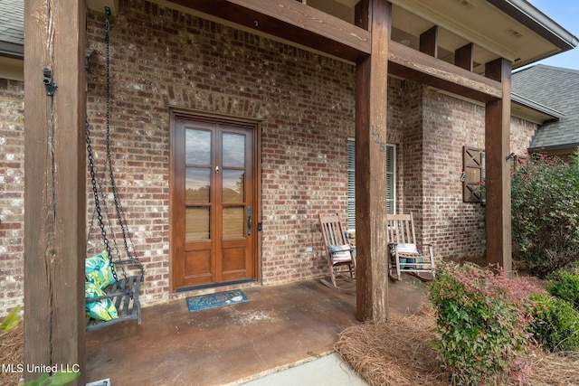 view of exterior entry featuring a porch and french doors