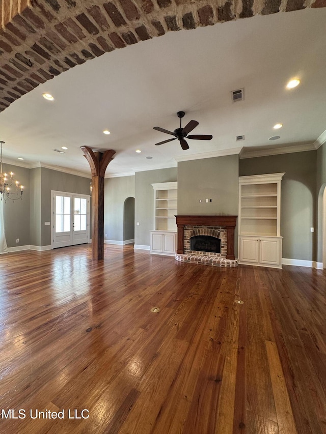 402 Ironwood Pl, Madison, MS 39110 - unfurnished living room with ceiling fan with notable chandelier, visible vents, a fireplace, arched walkways, and baseboards