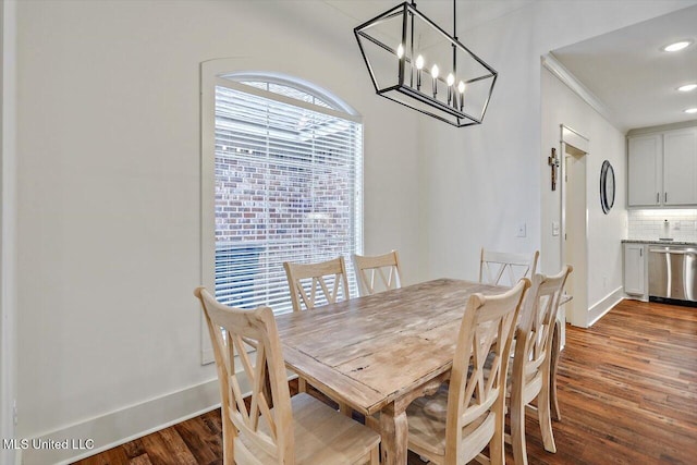 dining room featuring a notable chandelier, hardwood / wood-style flooring, and crown molding