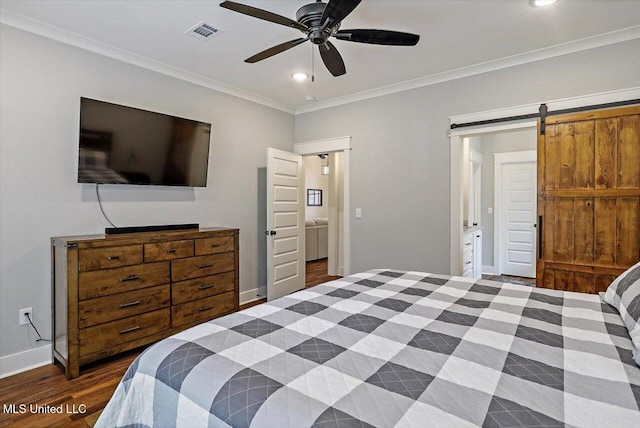 bedroom featuring ensuite bathroom, crown molding, a barn door, dark wood-type flooring, and ceiling fan